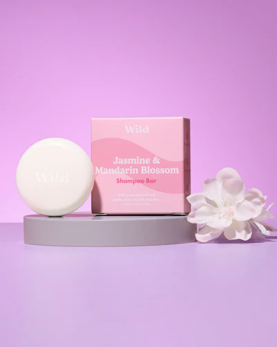 Caption: a soap bar sitting on top of a table next to a white flower