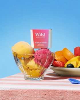 Caption: a bowl of fruit next to a bowl of ice cream