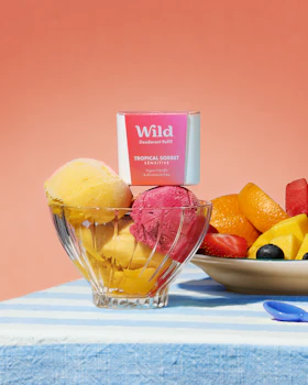 Caption: a bowl of fruit next to a bowl of ice cream