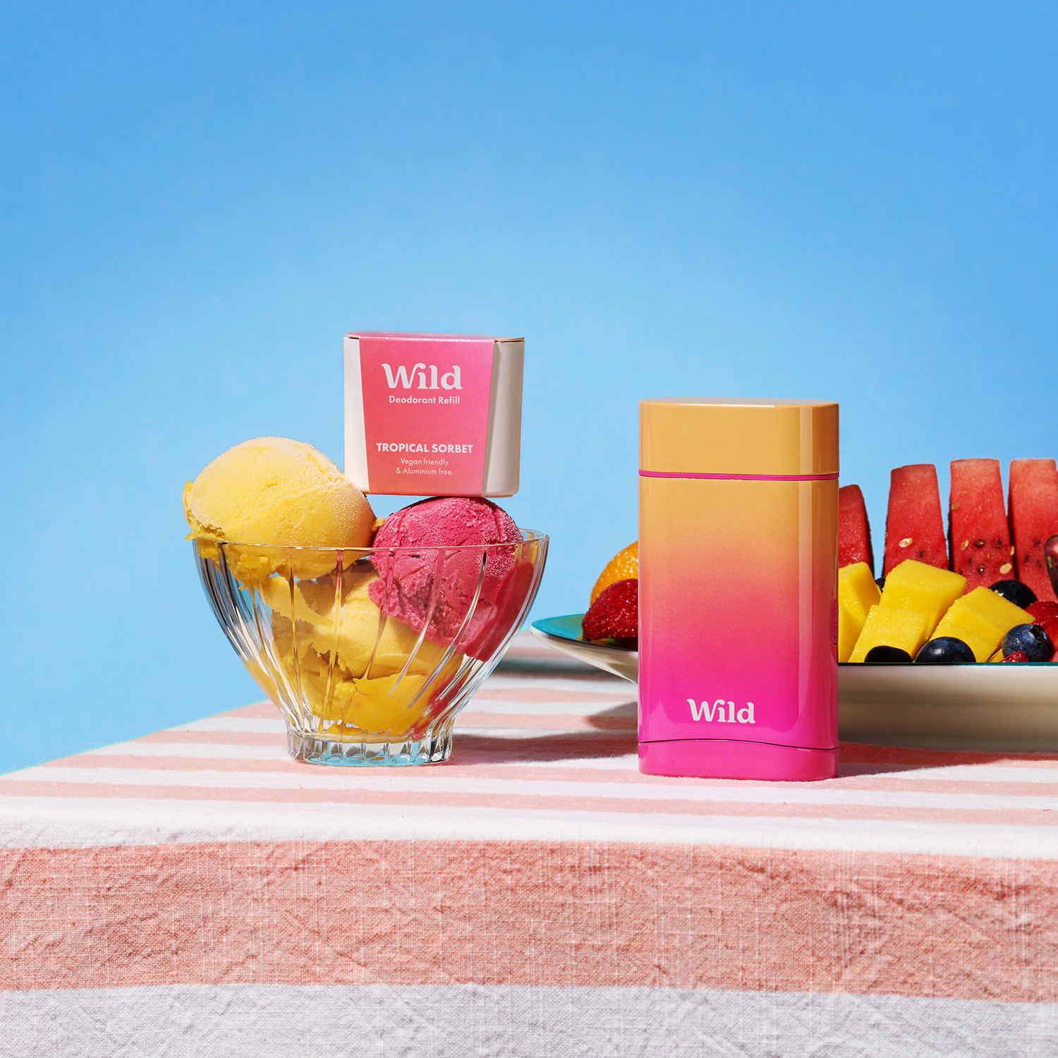 Bildunterschrift: ein Tisch mit einer Schale Obst neben einem Behälter mit Eiscreme