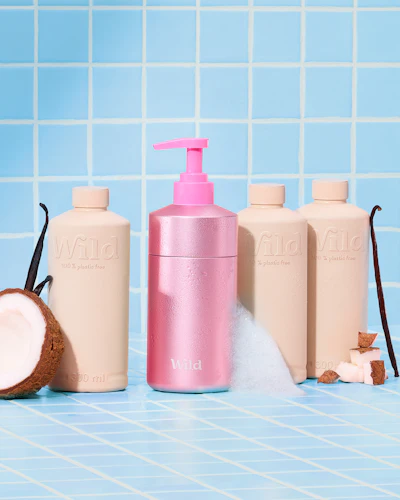 Bildunterschrift: eine Flasche mit Lotion, eine Flasche mit Lotion und eine Kokosnuss auf einem
