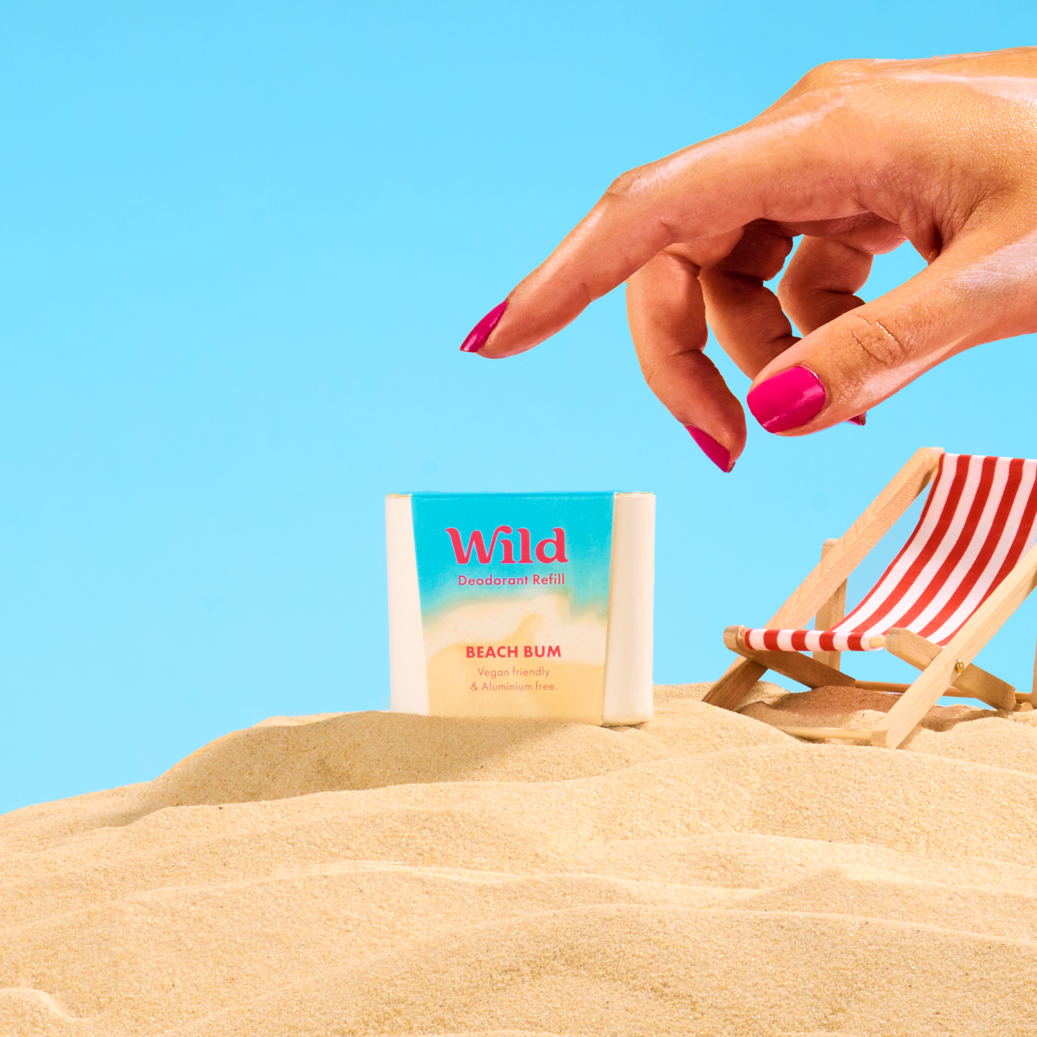Caption: a woman's hand reaching for a book on the beach