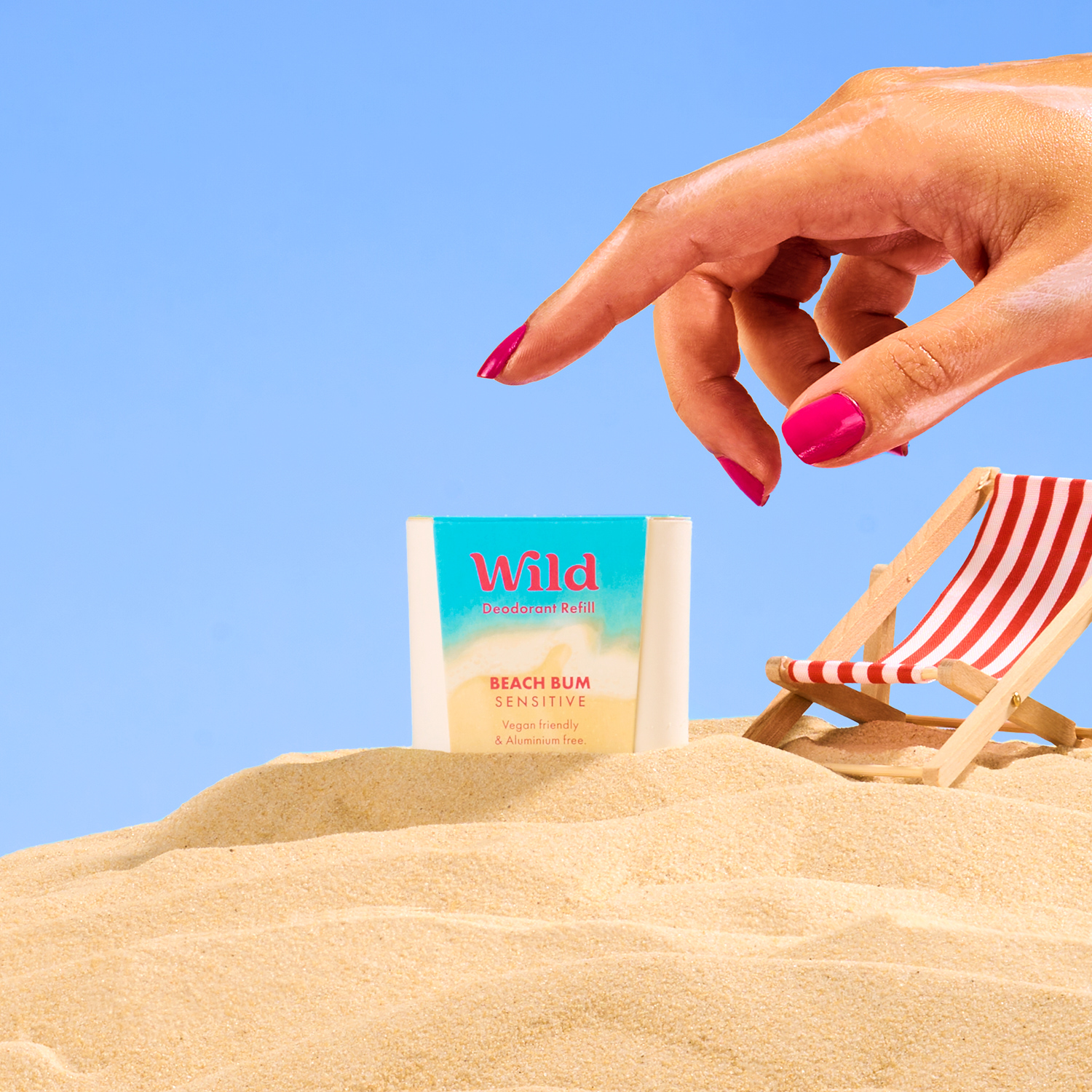 Caption: a woman's hand reaching for a book on the beach