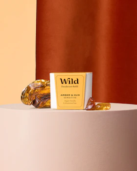 Caption: a bottle of wild on a table next to a bar of soap