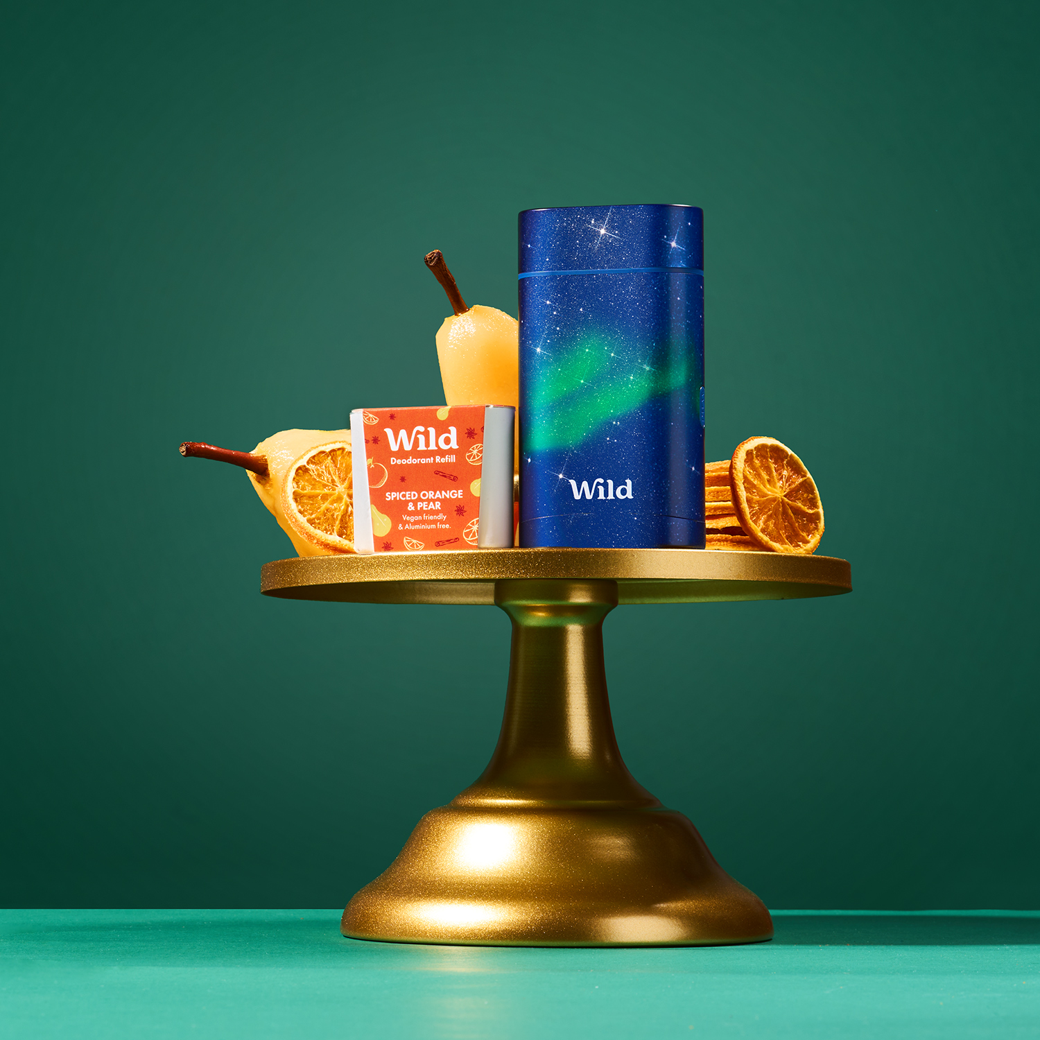 Caption: a gold stand holding a couple of oranges and a cup of tea