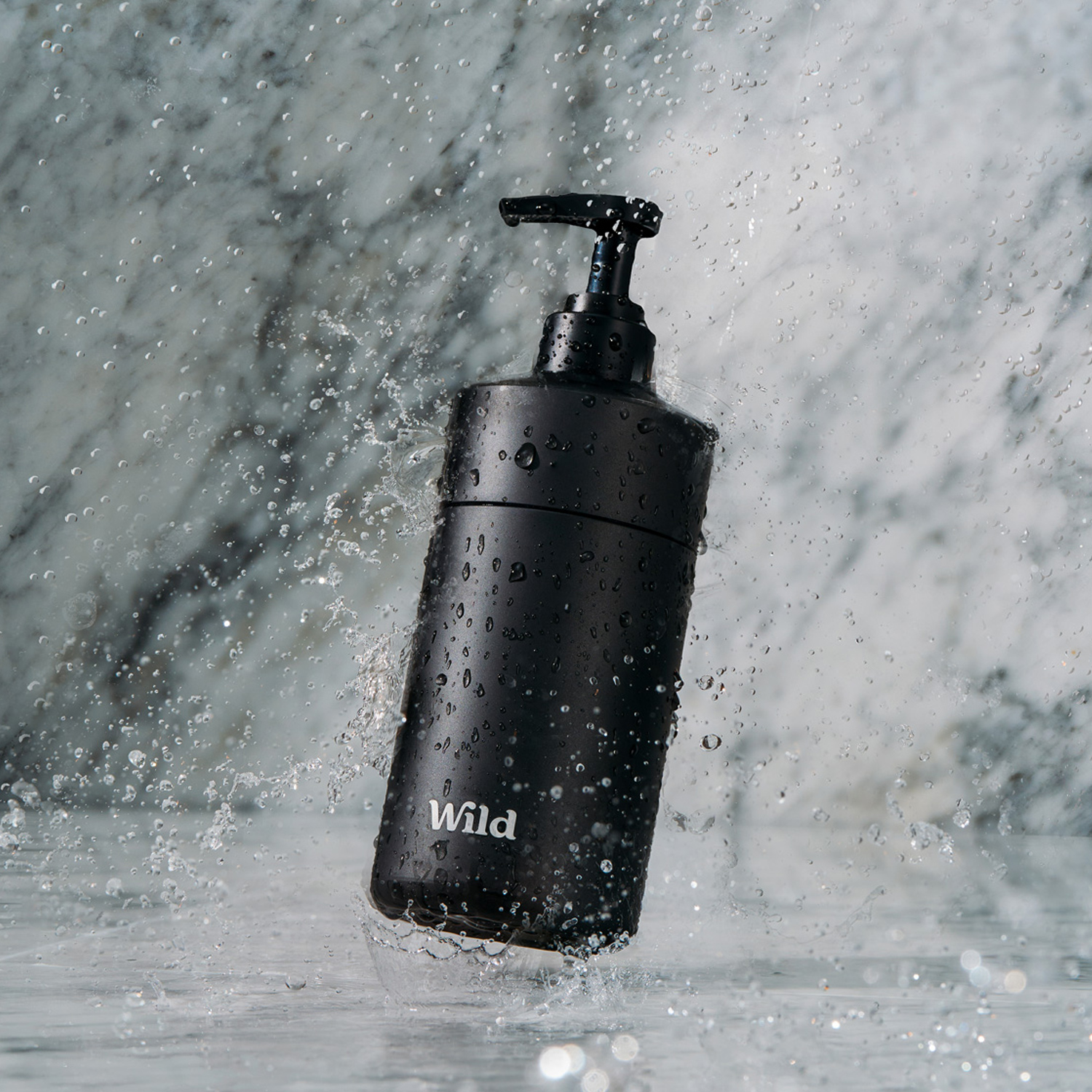Caption: a black hand soap dispenser splashing water