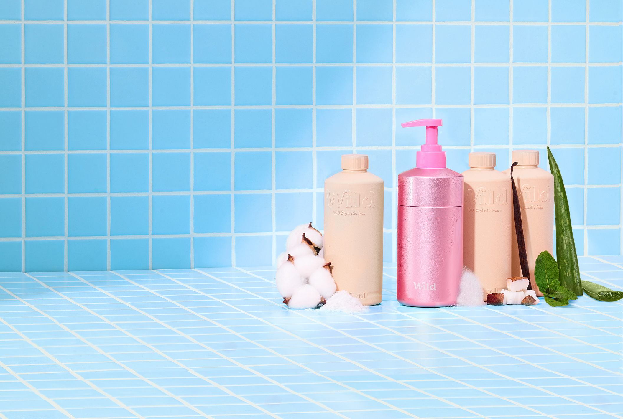 Caption: a blue tiled bathroom with a lot of soap and lotion