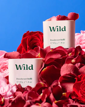 Caption: two boxes of wild deodorant balm surrounded by pink roses