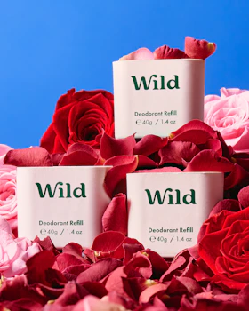 Caption: three packages of wild deodorant sitting on a bed of roses