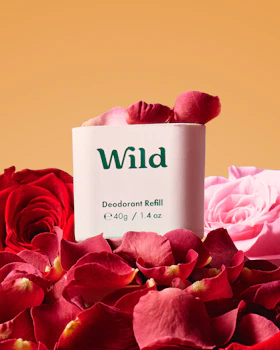 Caption: a tube of wild deodorant next to a bouquet of roses