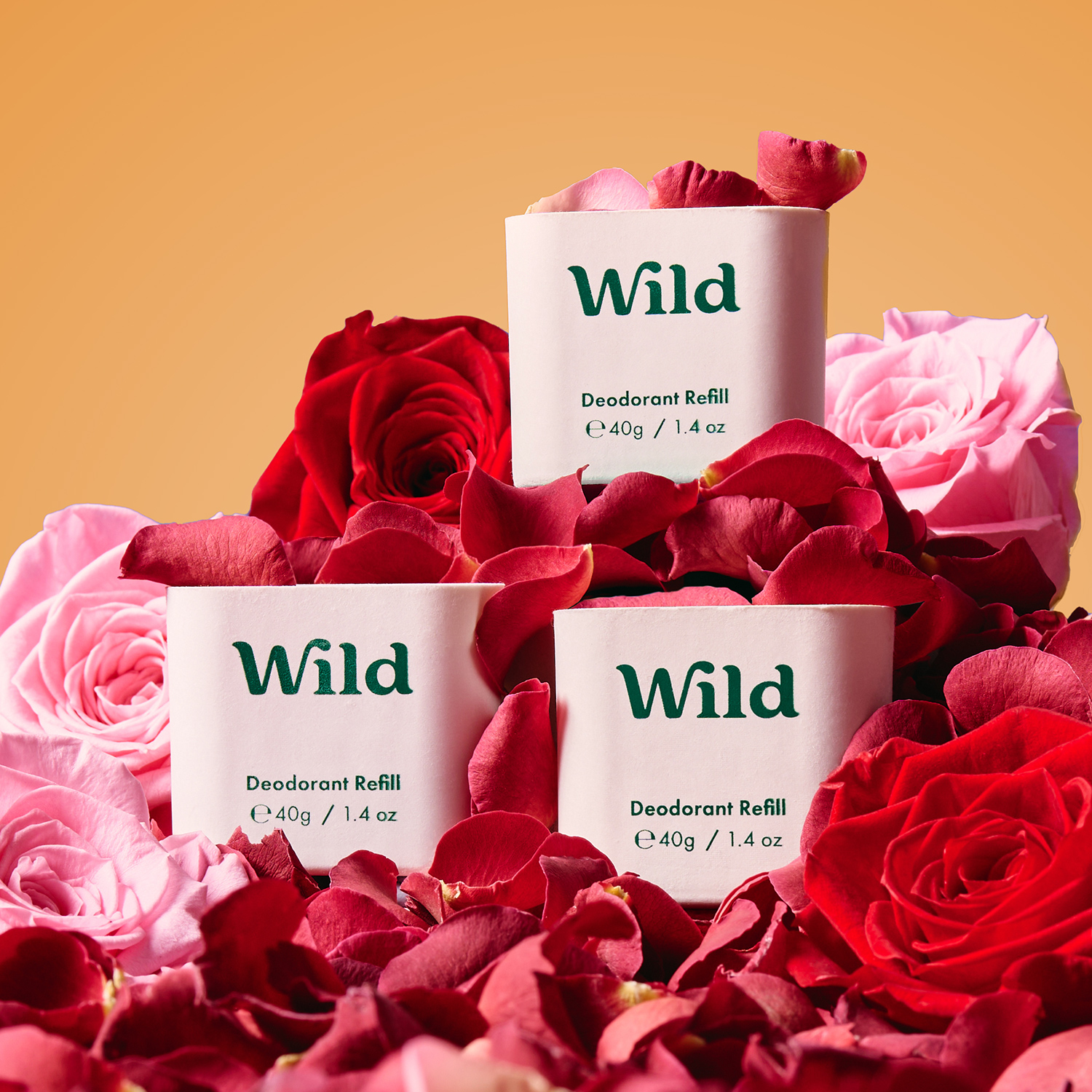 Légende : trois paquets de déodorant sauvage à côté de roses roses