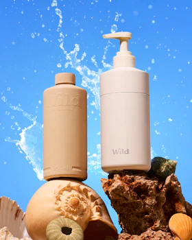 Caption: a bottle of lotion sitting next to a soap dispenser
