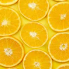 Caption: a group of oranges sitting on top of a yellow surface