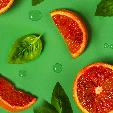 Légende : groupe de pamplemousses tranchés avec des feuilles sur une surface verte