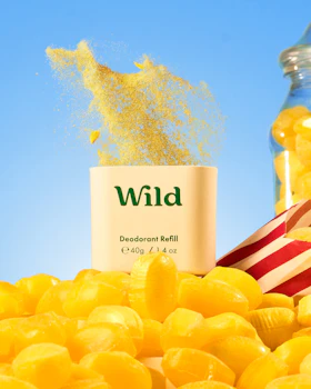 Caption: a pile of yellow candies next to a jar of wild deodorant