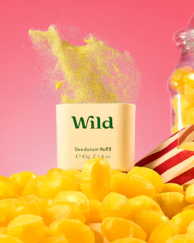 Caption: a pile of yellow candies next to a jar of wild deodorant