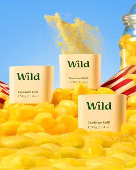 Caption: a pile of yellow candies next to a jar of wild
