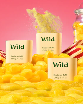 Caption: a pile of yellow candies next to a jar of wild
