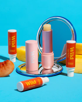 Didascalia: un tavolo blu con rossetto e uno specchio