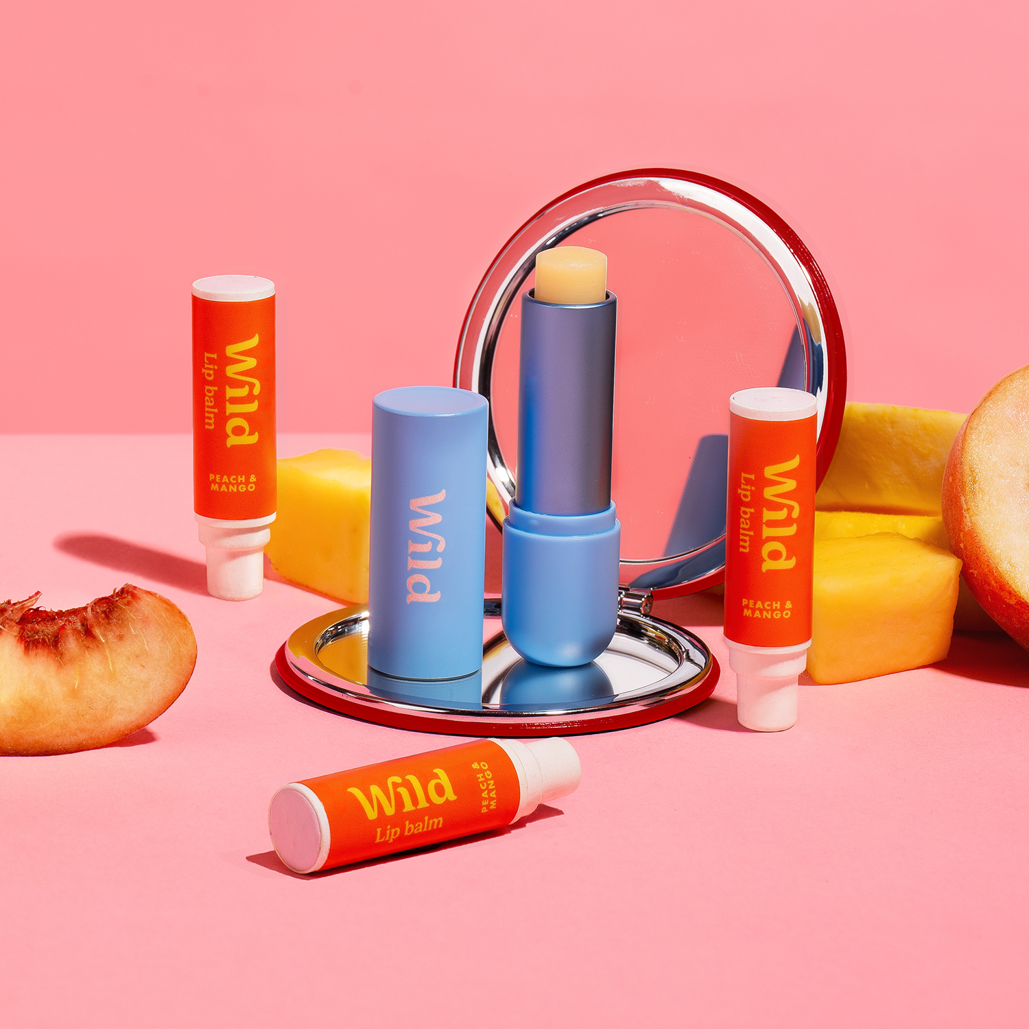 Bildunterschrift: ein rosa Hintergrund mit verschiedenen Lippenballen und Früchten