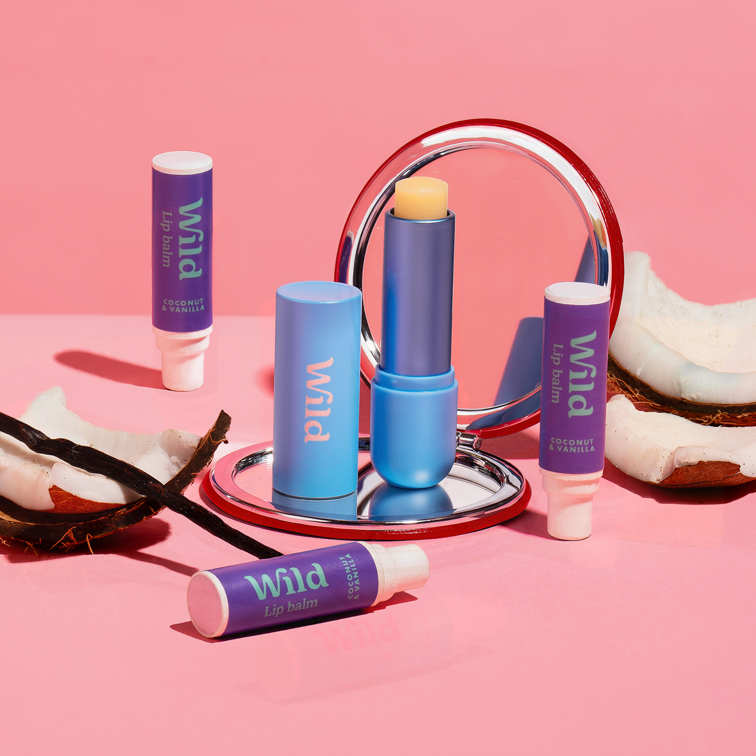 Bildunterschrift: ein rosafarbener Tisch mit einem Spiegel und einem Lippenstift auf dem Tisch