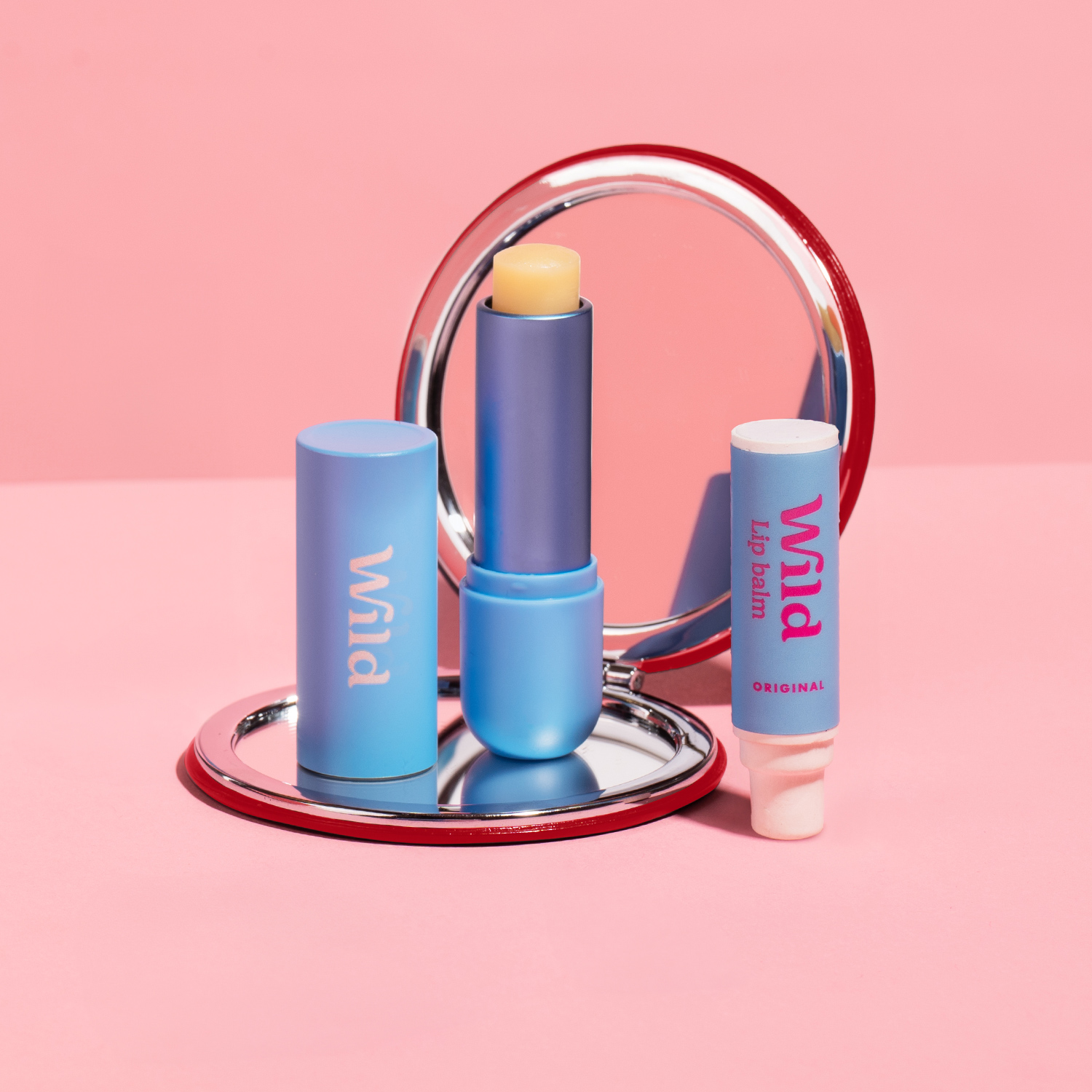 Caption: a blue lip balm and a mirror on a pink background