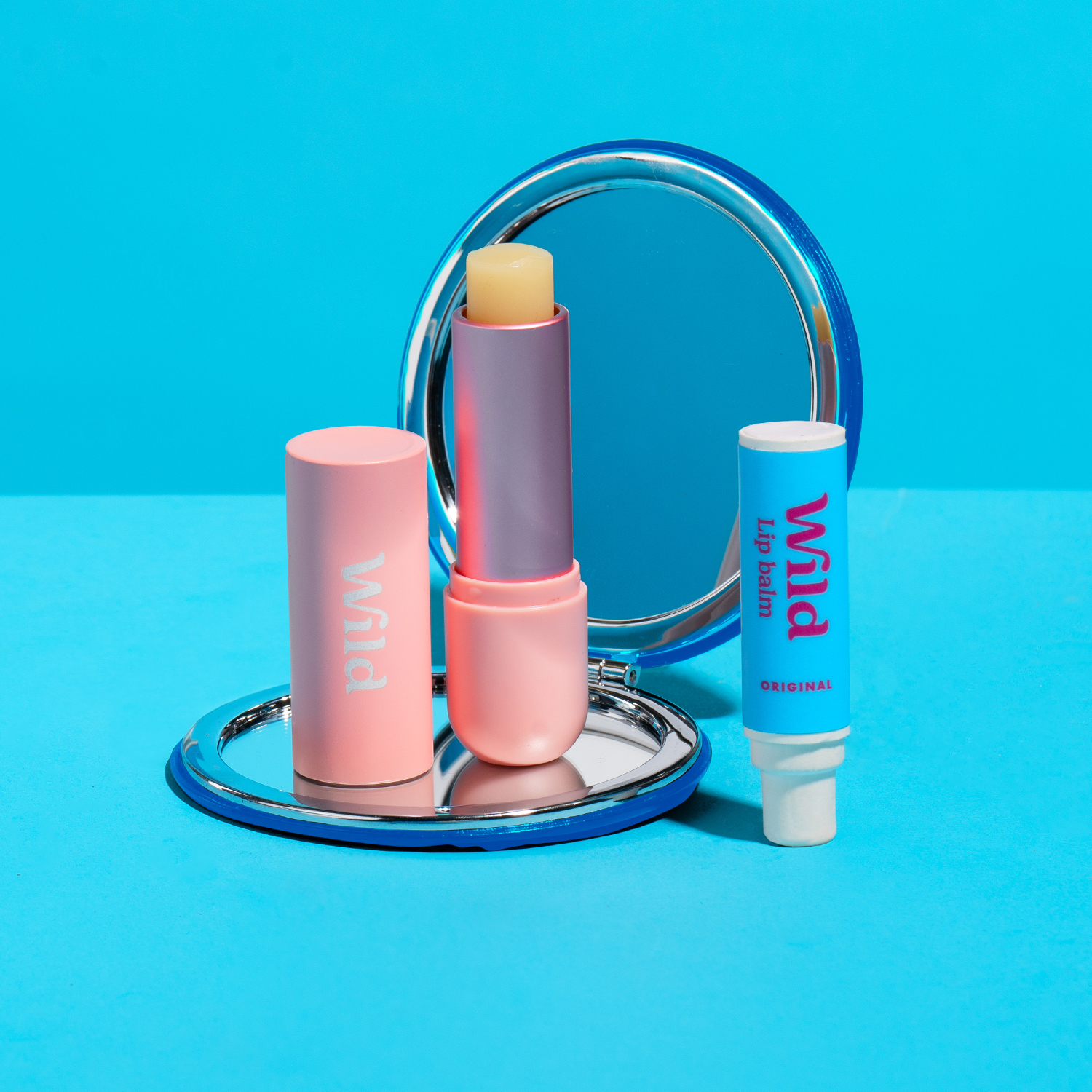 Caption: a pink lipstick and a mirror on a blue background