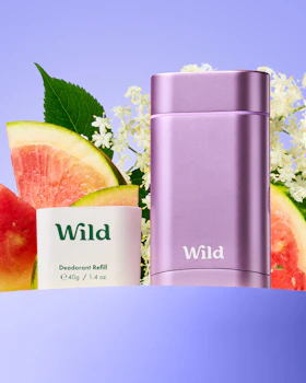 Caption: a bottle of wild next to some fruit and flowers