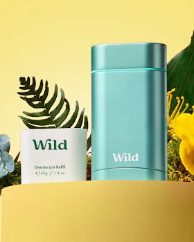 Onderschrift: een fles wilde deodorant naast een plant