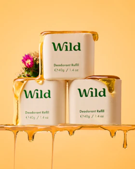 Caption: three containers of wild deodorant sitting on a shelf