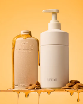 Didascalia: una bottiglia di liquido accanto a una bottiglia di olio di mandorle