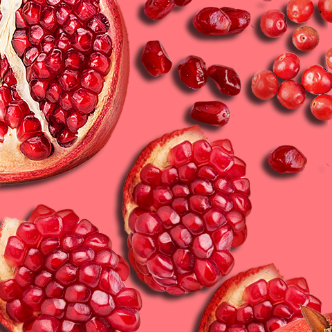 Caption: a bunch of pomegranates on a pink background
