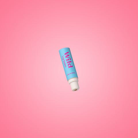 Bildunterschrift: eine Tube Lippenbalsam auf einem rosa Hintergrund