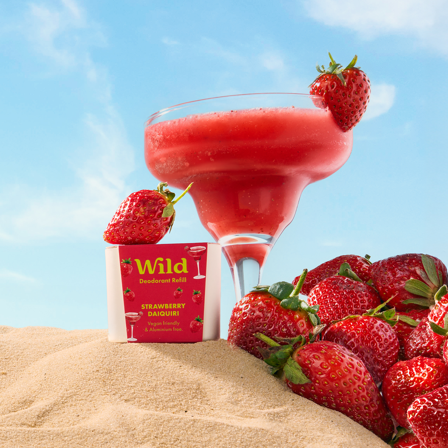 Caption: a drink and strawberries on a sand dune