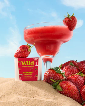 Caption: a drink and strawberries on a sand dune