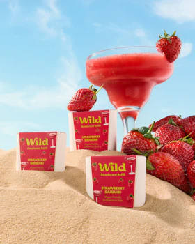 Caption: three packets of wild strawberry juice next to a glass of strawberries