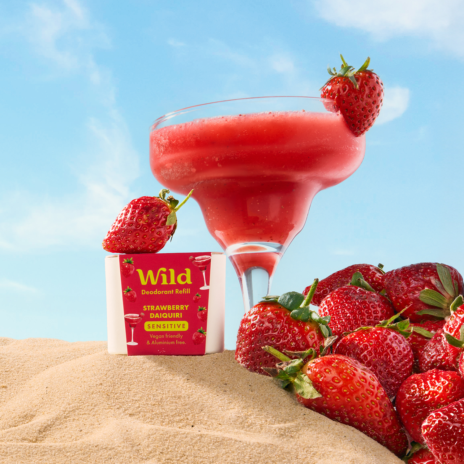 Caption: a drink and strawberries on a sandy beach