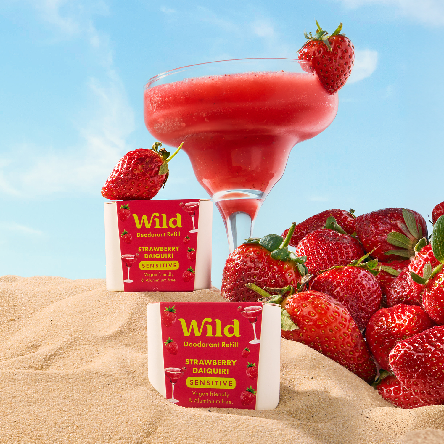 Caption: a drink and strawberries on a sandy beach