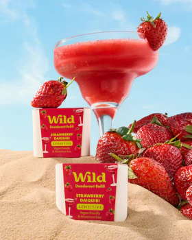 Caption: a drink and strawberries on a sandy beach