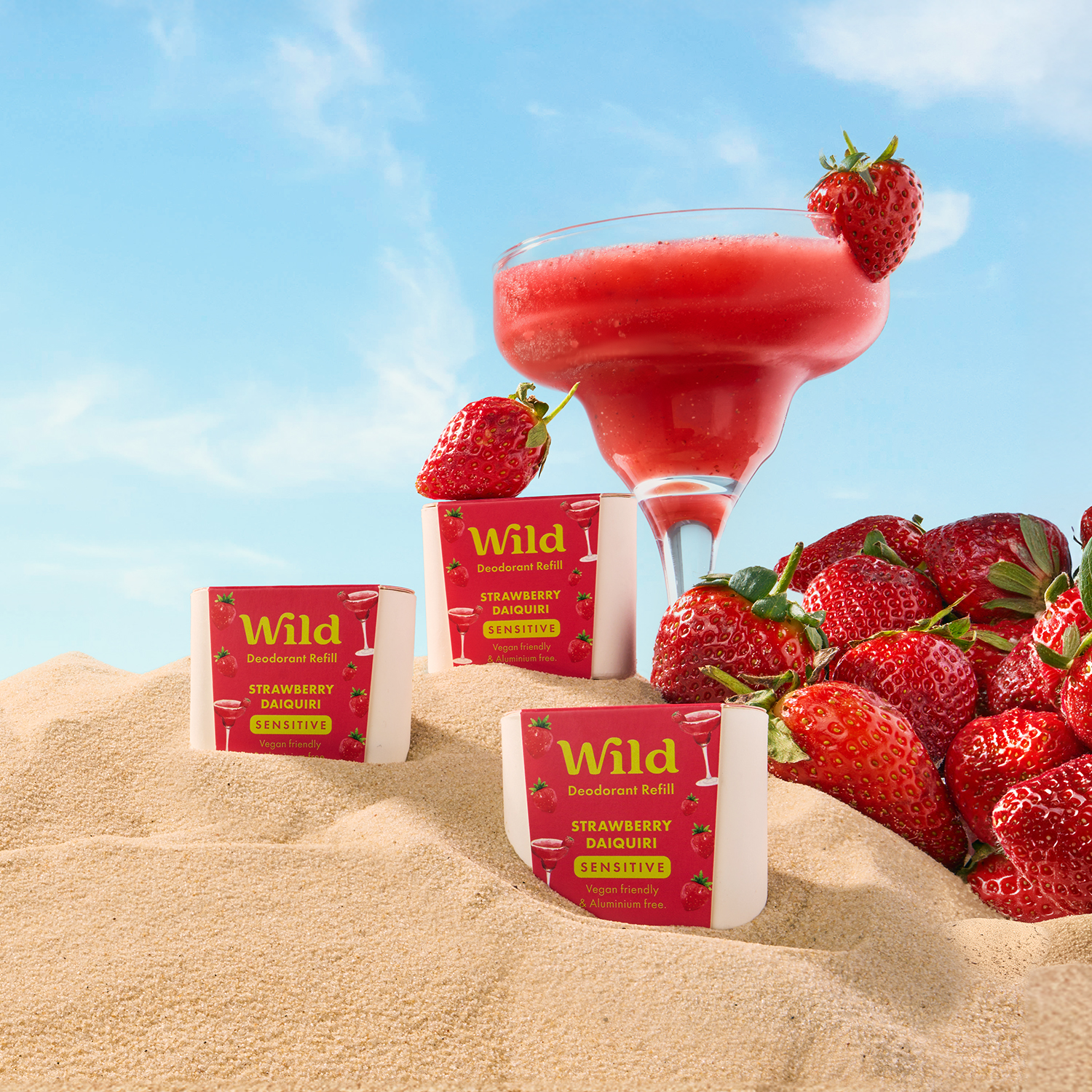 Caption: strawberries and a drink on a sandy beach