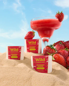 Caption: strawberries and a drink on a sandy beach