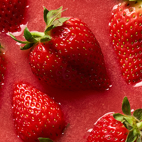Caption: a group of strawberries sitting on top of a red surface