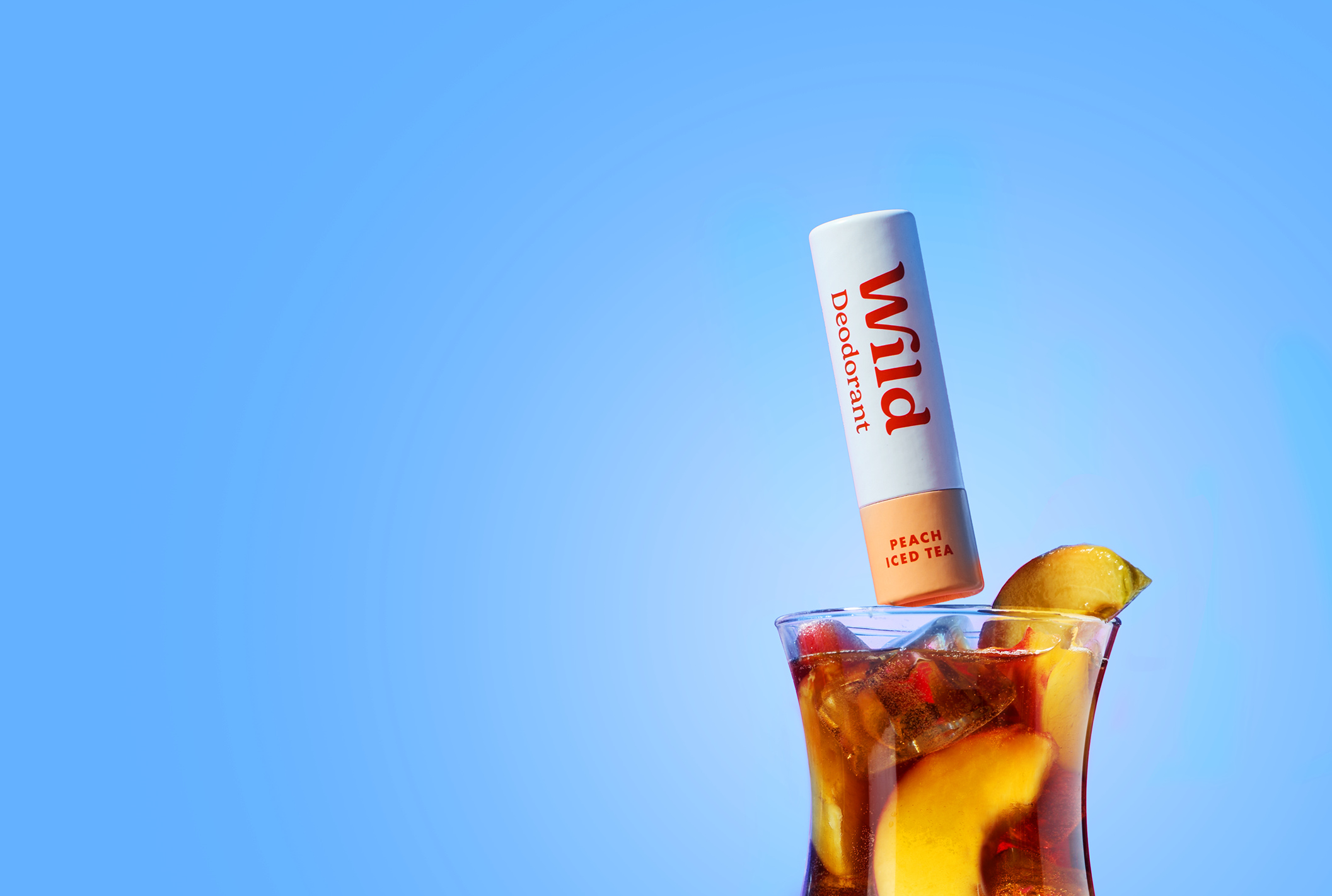 Bildunterschrift: ein Glas Eistee mit einer Tube Lippenbalsam