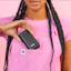Caption: a woman in a pink shirt holding a cell phone
