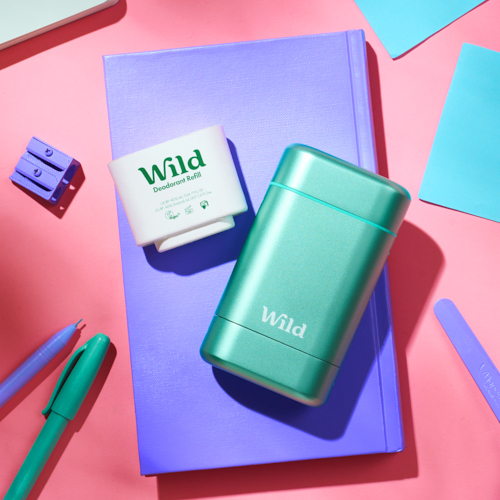 Bildunterschrift: ein grünes Feuerzeug und ein blaues Notizbuch auf einer rosa Fläche