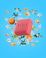 Caption: a soap bar with the word wild surrounded by oranges and flowers