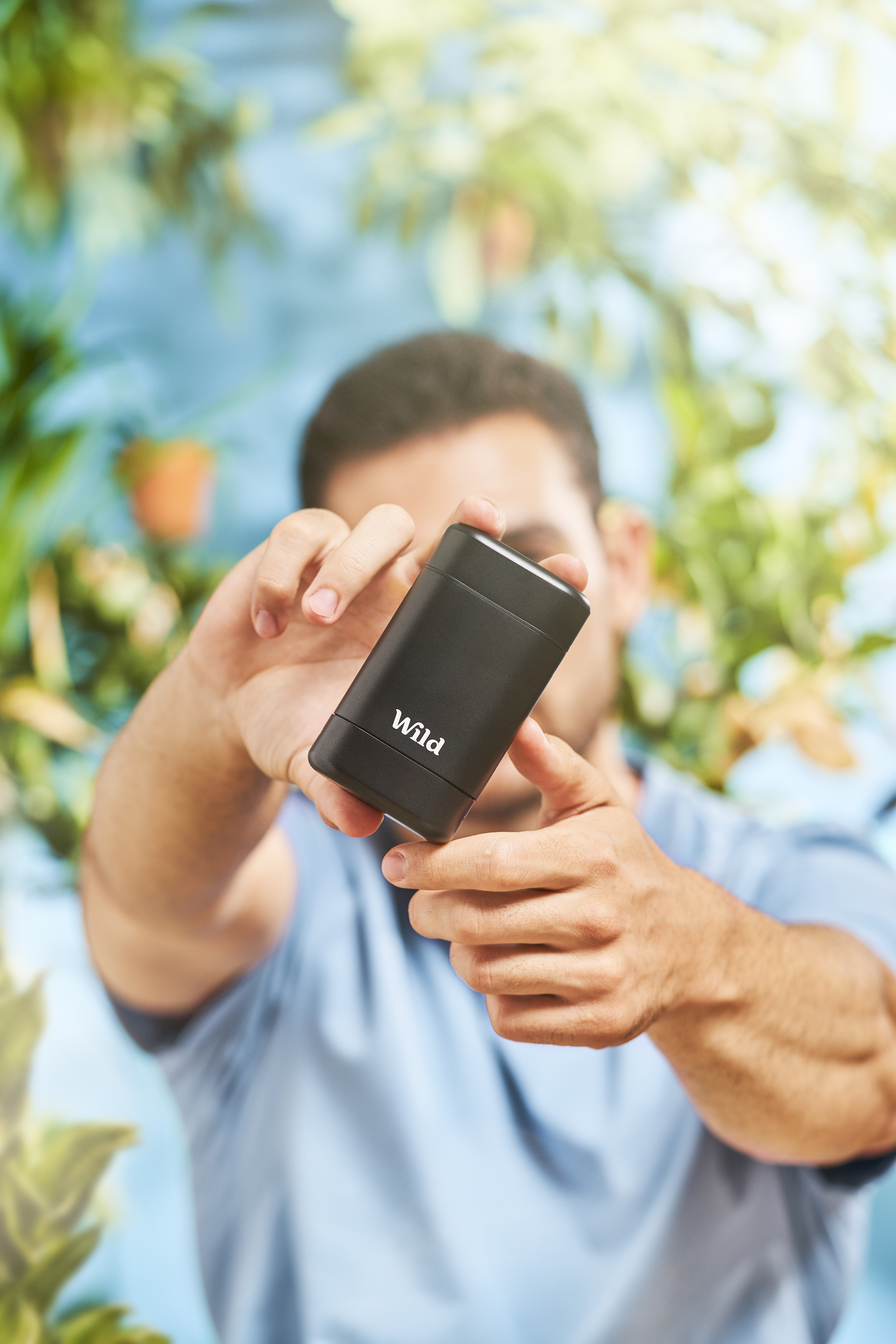 Caption: a man holding a cell phone in his hand