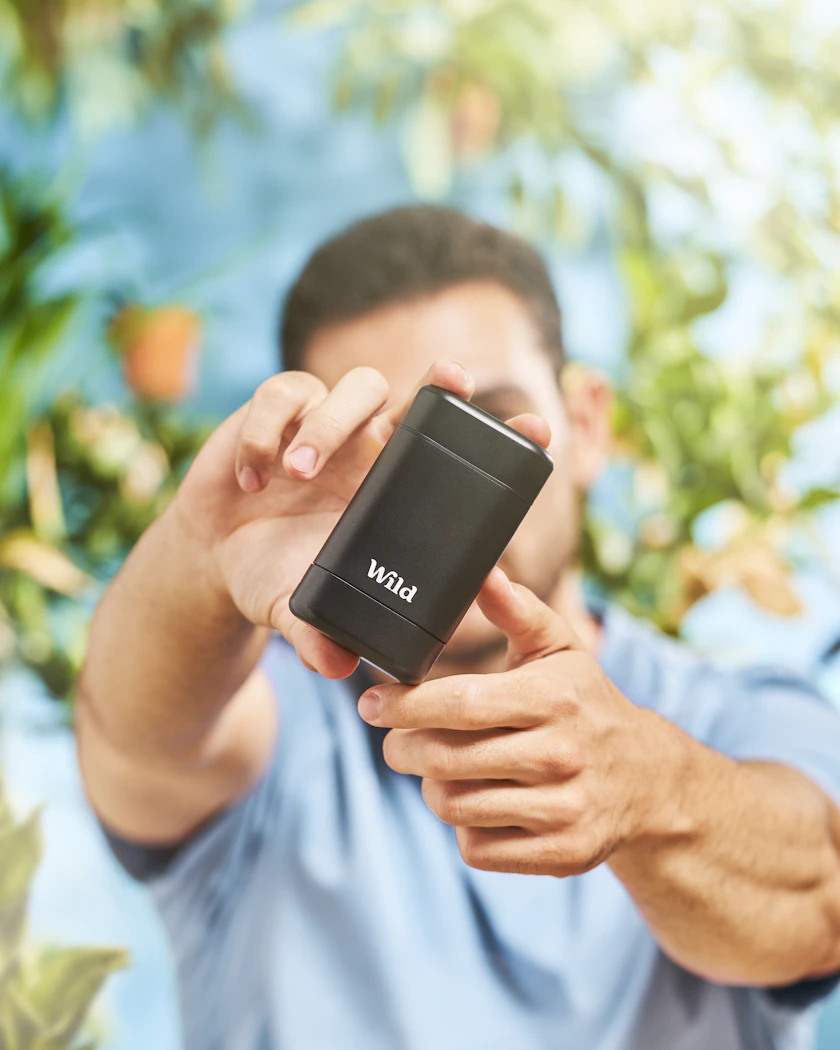 Caption: a man holding a cell phone in his hand