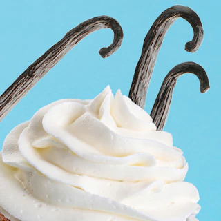 Caption: a cupcake with white frosting and chocolate sticks sticking out of it