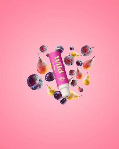 Caption: a tube of lip butter surrounded by fruit on a pink background